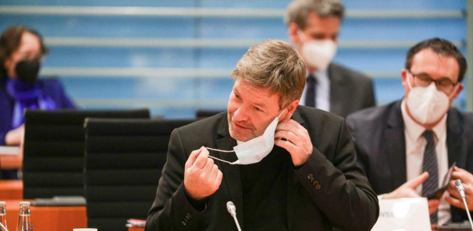 El ministro alemán de Economía y Protección del Clima, Robert Habeck, se quita la mascarilla que se muestra en la foto antes de la reunión semanal del gabinete en la Cancillería en Berlín el 22 de diciembre de 2021. Omer Messinger / PISCINA / AFP