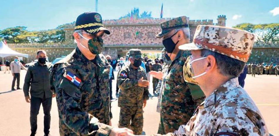 El presidente Luis Abinader, con chaqueta y gorra militar, saludas a oficiales del Ejército. durante la actividad realizada ayer en la ciudad fronteriza de Elías Piña.