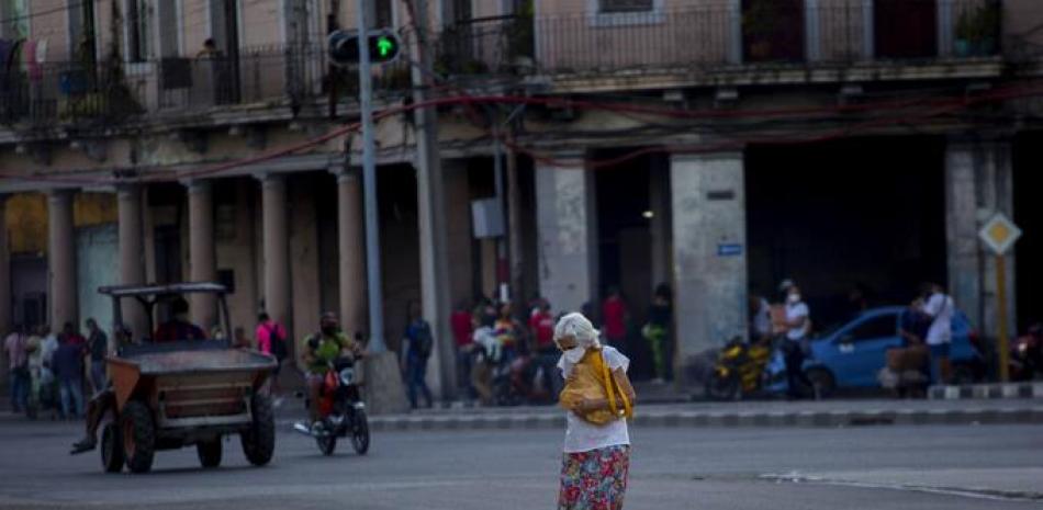 Una mujer, con una máscara protectora, cruza una calle en La Habana, Cuba, el jueves 30 de diciembre de 2021, en medio de la nueva pandemia de coronavirus.

Foto: AP / Ismael Francisco