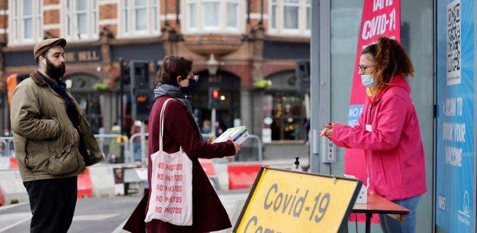Personas hacen cola para recibir un kit de prueba de flujo lateral rápido Covid-19 gratuito en un punto de distribución en Hoe Street en Walthamstow, al norte de Londres, el 30 de diciembre de 2021.

Foto: Tolga Akmen / AFP