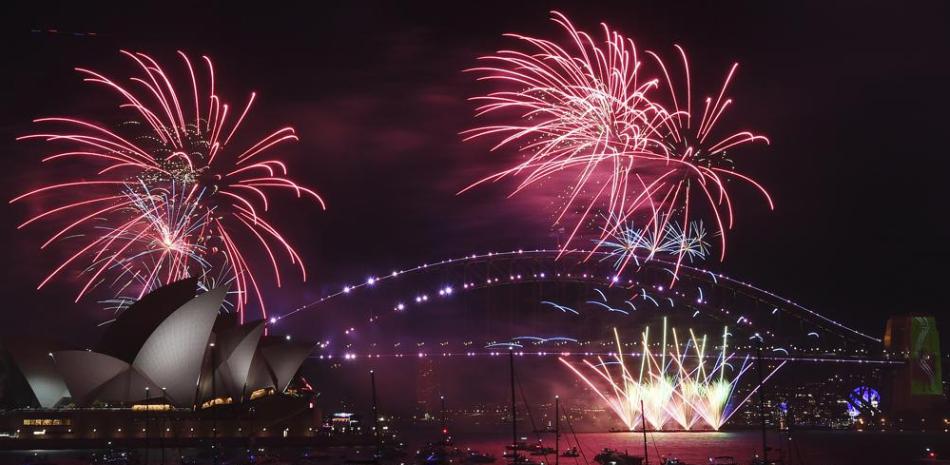 Fuegos artificiales iluminan el puente y la ópera de Sydney en el inicio de los festejos de Año Nuevo, el Sydney, el 31 de diciembre de 2021. (Dean Lewins/AAP Image via AP)