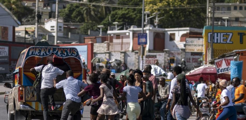 La gente se apresura a abordar un vehículo de transporte público conocido localmente como tap tap en Puerto Príncipe, Haití, el 28 de octubre de 2021.

Foto: Ricardo Arduengo/ AFP