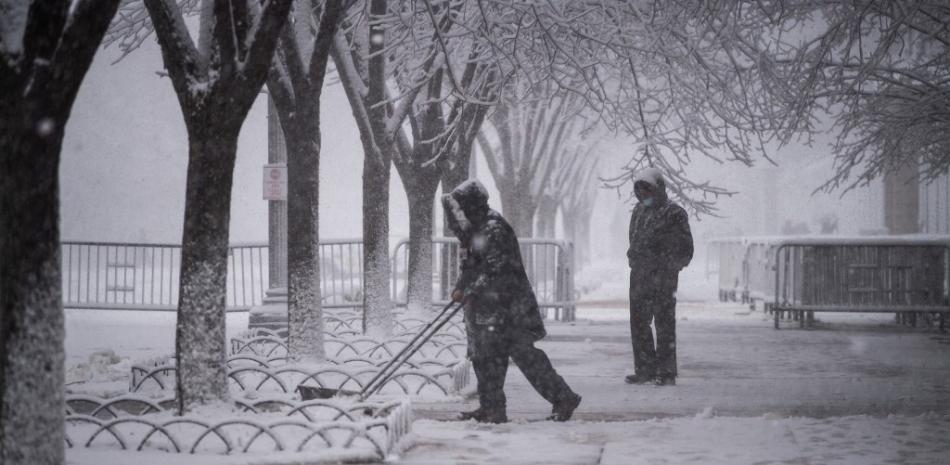 Los trabajadores limpian la nieve de las aceras adyacentes a la Casa Blanca en Washington, DC el 3 de enero de 2022. 

Foto: ROBERTO SCHMIDT / AFP
