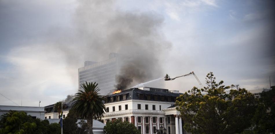 Los bomberos intentan extinguir un incendio en la Asamblea Nacional, la cámara principal de los edificios del Parlamento sudafricano en Ciudad del Cabo, el 3 de enero de 2022. RODGER BOSCH / AFP
