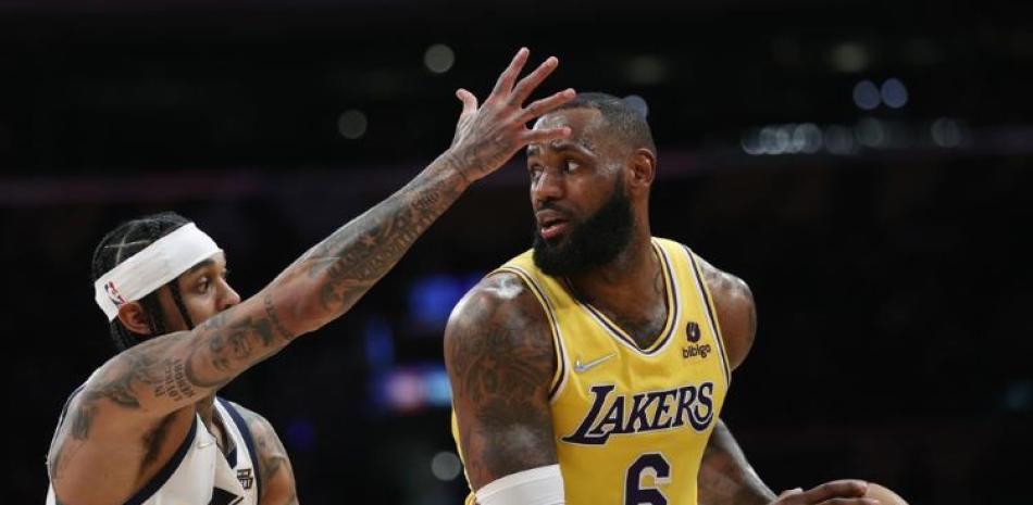 El alero de los Lakers de Los Ángeles LeBron James intenta pasar el balón mientras lo defiende Jordan Clarkson del Jazz de Utah en el encuentro del lunes.