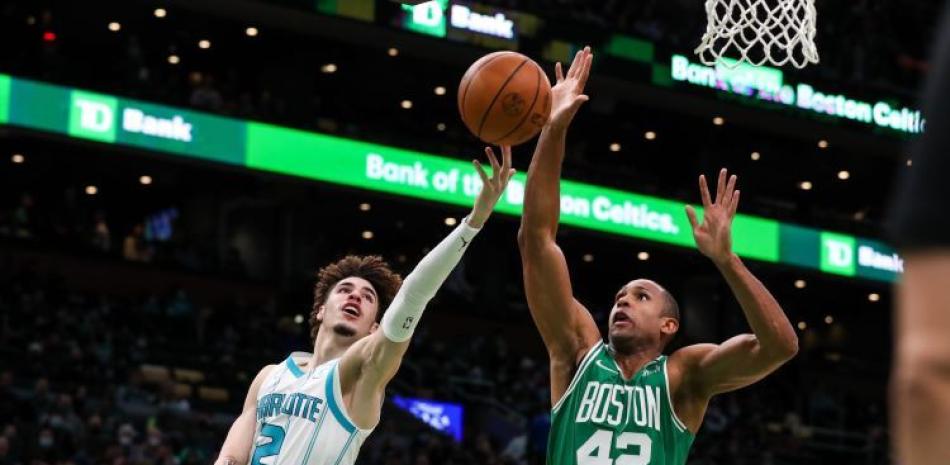 Al Horford, de los Celtics, trata de evitar un canasto de LaMelo Ball, de los Hornets, en acción del partido de la NBA.