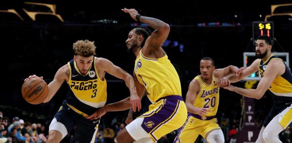 Chris Duarte, de los Pacers, maneja el balón ante la defensa de Trevor Ariza, de los Lakers, durante el partido del miércoles en el baloncesto de la NBA.