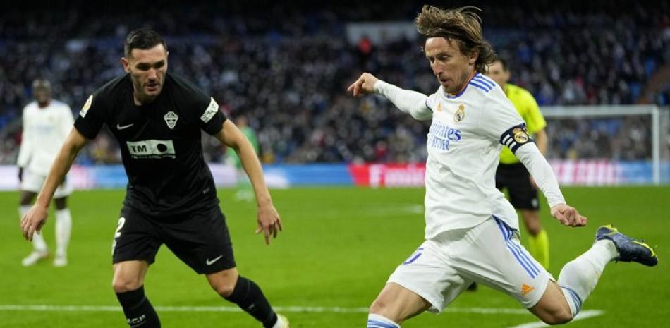 Luka Modric del Real Madrid y Gerard Gumbau del Elche pelean por el balón durante el encuentro de la liga española.