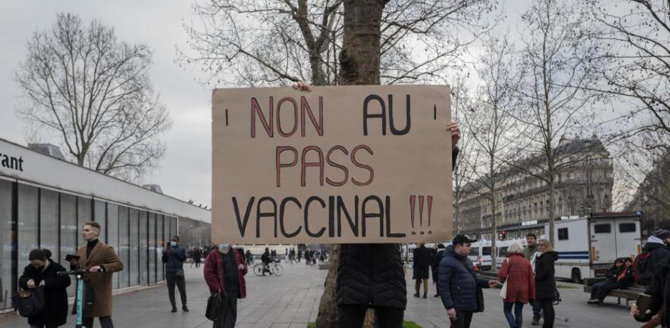 Una persona sostiene un cartel con el mensaje "¡No al pase de vacunas!" en una protesta contra el pase de vacunas contra el COVID-19, en París, Francia, el sábado 22 de enero de 2022. Foto: Rafael Yaghobzadeh/AP.