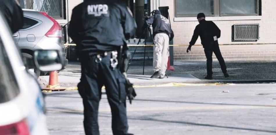 La policía se reúne en la escena en Harlem donde un agente murió y otro resultó herido. /AFP