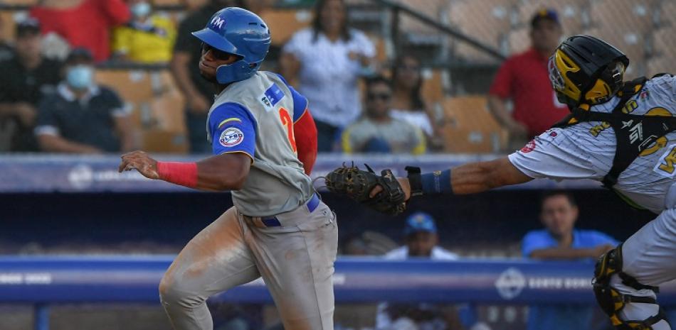Ándres Angulo, de Colombia, es puesto out en el plato por el catcher de Venezuela José Nieto en acción del partido de segunda hora en la jornada inaugural de la Serie del Caribe.