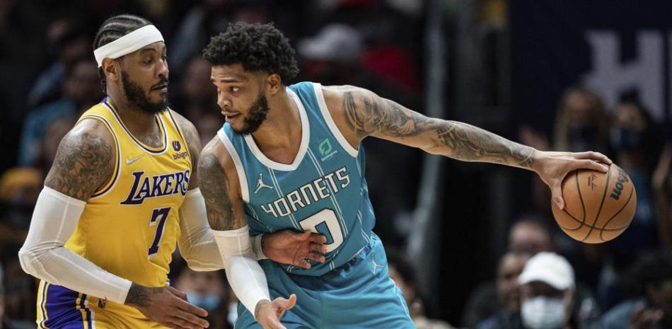 Carmelo Anthony, de los Lakers de Los Ángeles, defiende a Miles Bridges, de los Hornets de Charlotte, durante la segunda mitad del juego de la NBA en Charlotte. (AP Foto/Jacob Kupferman)