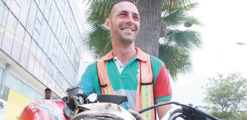 Dalibor Ristic, un joven de nacionalidad serbia, montado en su moto en una vía de Santo Domingo, y en cuyo medio gana para apenas subsistir.