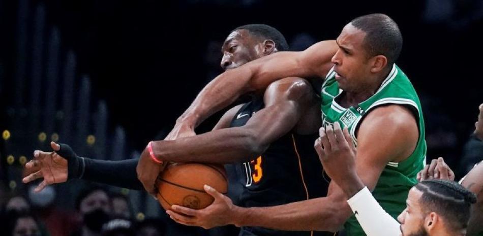 Al Horford, de los Celtics, y Bam Adebayo, de los Heat, luchan por el control del balón en acción del partido de la noche del lunes en el baloncesto de la NBA.