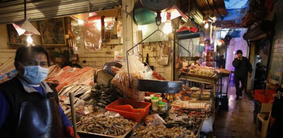 ARCHIVO - Vendedores esperan clientes en el mercado de mariscos La Nueva Viga, parte de la Central de Abastos, el principal mercado de la capital, en la Ciudad de México, el 9 de diciembre de 2020. (AP Foto/Rebecca Blackwell, Archivo)