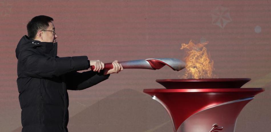 El viceprimer ministro de China, Han Zheng, enciende la antorcha olímpica antes del inicio del relevo para los Juegos Olímpicos de Invierno de Beijing 2022, en el parque olímpico de Beijing.