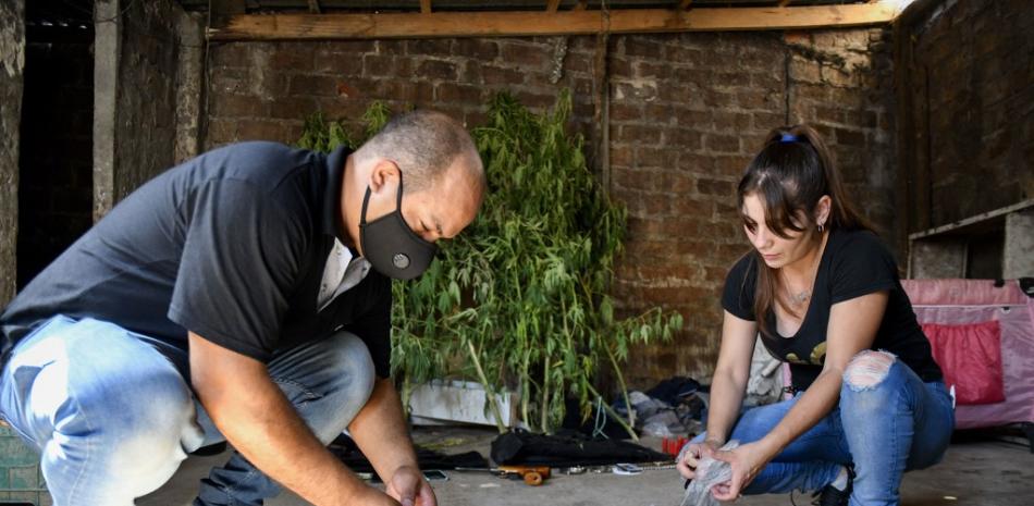 En esta foto difundida por TELAM, la Policía organiza paquetes que presuntamente contenían droga incautada durante un allanamiento en la villa Villa Puerta 8, provincia de Buenos Aires, el 2 de febrero de 2022. Doce personas murieron y otras 50 fueron trasladadas a un hospital en un suburbio del noroeste de Buenos Aires. después de consumir cocaína adulterada, dijeron las autoridades el miércoles. Eliana OBREGÓN / AFP