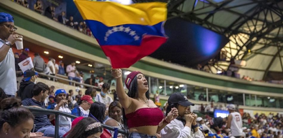 Una aficionada de los Navegantes ondea orgullosa la bandera de Venezuela en el Estadio Quisqueya Juan Marichal.