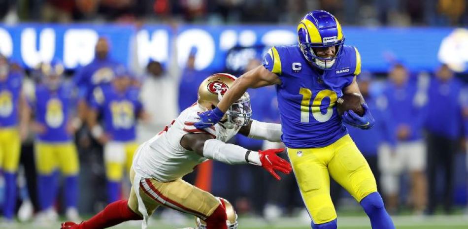 Cooper Kupp (10), de Los Angeles Rams, corre con el balón ante la defensa de Fred Warner y K'Waun Williams, de San Francisco, en el partido por el campeonato de la NFC.