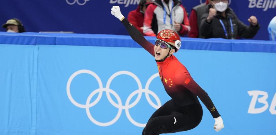 El chino Wu Dajing festeja tras cruzar la meta para ganar la final de relevos mixtos por equipos en pista corta, el sábado 5 de febrero de 2022, en los Juegos Olímpicos de Invierno en Beijing.