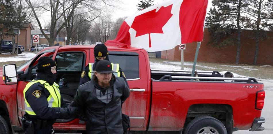 La policía detiene a un manifestante mientras despeja a las protestas contra los mandatos de vacunas contra el covid-19 que bloquearon la entrada al puente Ambassador en Windsor, Ontario, Canadá, el 13 de febrero de 2022. Foto: Jeff Kowalsky/AFP.