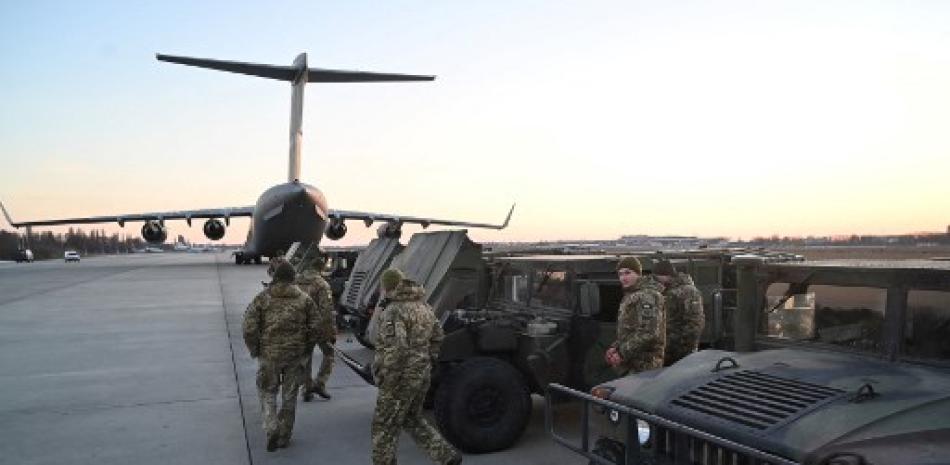 Fuerzas militares ucranianas examinan los camiones militares del vehículo de ruedas multipropósito de alta movilidad (HMMWV) enviados desde Lituania al aeropuerto de Boryspil en Kiev el 13 de febrero de 2022. Foto: AFP.