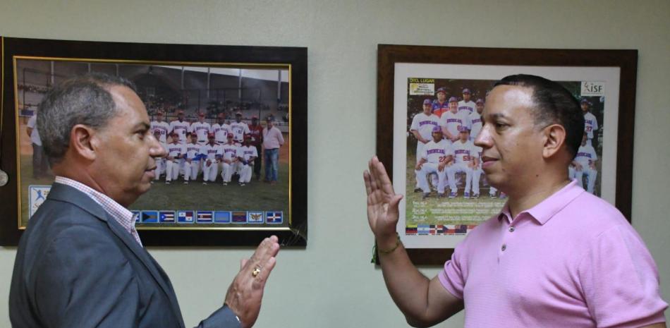 Garibaldy Bautista (izquierda), presidente de la Federación Dominicana de Softbol, juramenta a Fabio De León Sánchez como gerente general de selección nacional.