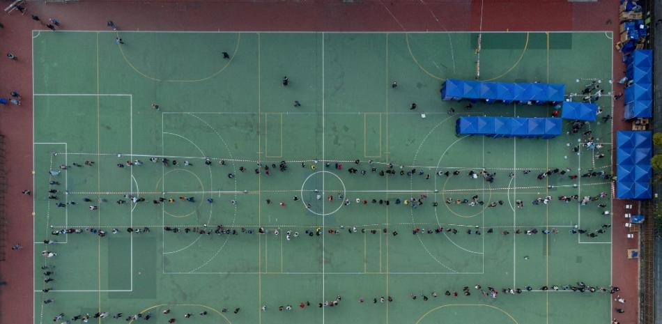 Esta foto aérea muestra a los residentes formando largas colas en una estación móvil de recolección de muestras al aire libre para la prueba de COVID-19 en Hong Kong el 11 de febrero de 2022, luego de otro número récord de nuevas infecciones por Covid-19.
Yan Zhao / AFP