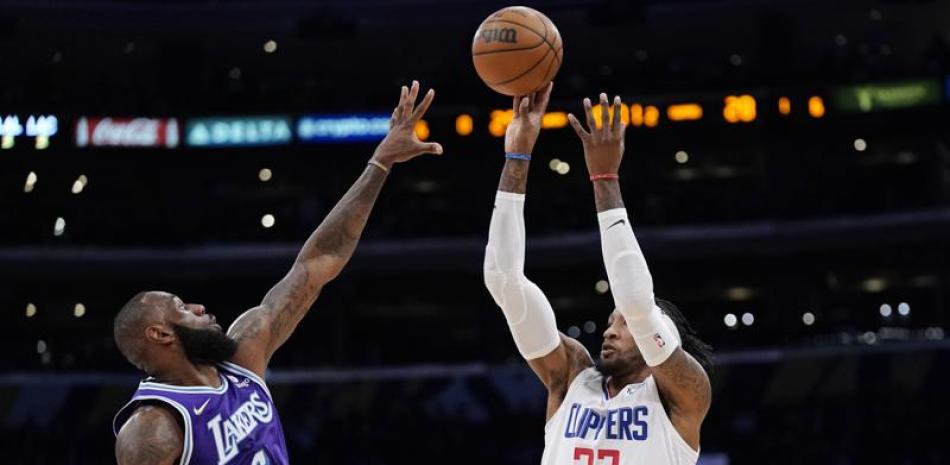 Roberg Covigton, de los Clippers, realiza un jumper ante la defensa de LeBron James.