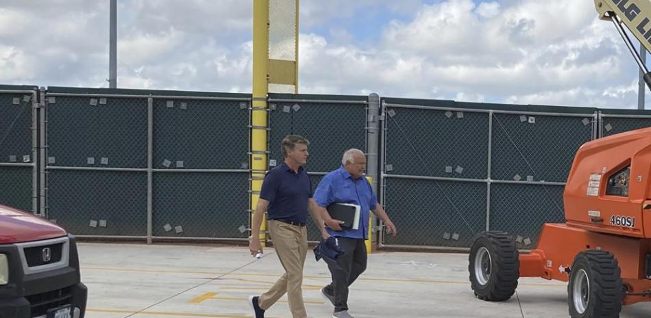 El socio gerente general de los Yankees de Nueva York, Hal Steinbrenner, a la izquierda, y el vicepresidente de los Padres de San Diego, Ron Fowler, caminan en el estadio Roger Dean en Jupiter, Florida, donde continúan las negociaciones laborales del béisbol.