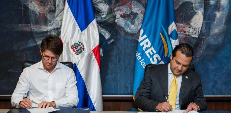 Willy Pumarol y José Manuel Almonte, subadministrador de Banreservas, durante la firmar del convenio.