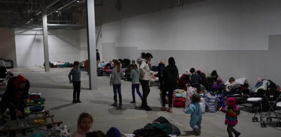 Refugiados ucranianos esperan a ser transportados a otros destinos, el 4 de marzo de 2022 en un centro comercial vacío en Przemysl, Polonia. Foto: Janek Skarzynski/AFP.