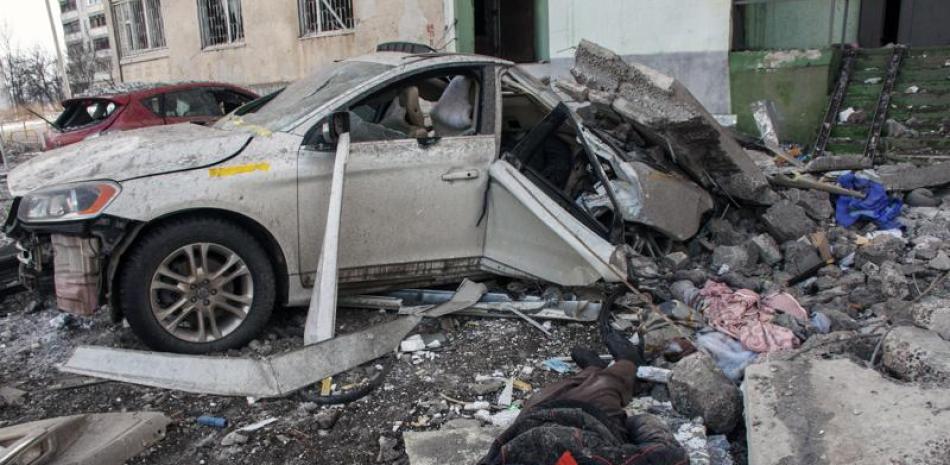 El cadáver de un hombre muerto en un ataque de un cohete ruso yace entre escombros, el domingo 6 de marzo de 2022, en Járkiv, la segunda ciudad más grande de Ucrania. (AP Foto/Andrew Marienko)