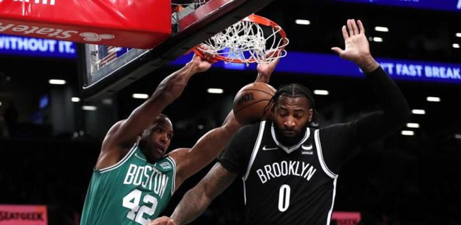 Boston Celtics center Al Horford (42) dunks against Brooklyn Nets center Andre Drummond (0) during the first half of an NBA basketball game, Thursday, Feb. 24, 2022, in New York