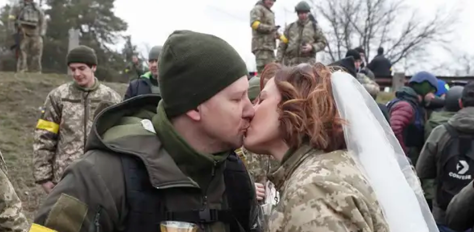 Los combatientes de defensa territorial ucranianos Valeriy y Lesya durante su ceremonia de boda en un puesto de bloqueo cerca de Kiev, Ucrania. SERGEY DOLZHENKO / EFE