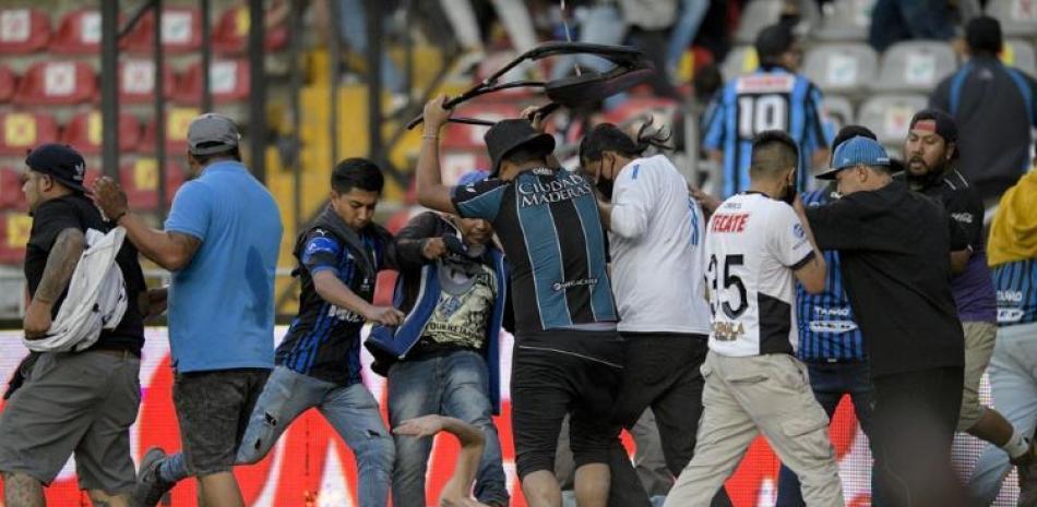 Aficionados del Querétaro y del Atlas riñen durante un partido de la Liga MX, el sábado 5 de marzo de 2022, en el Estadio Corregidora de Querétaro.