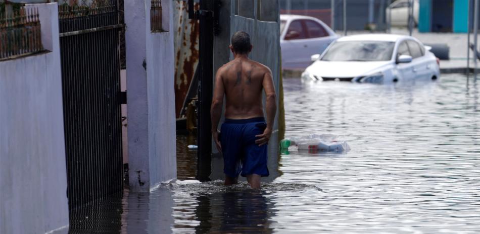 Un hombre camina por una calle inundada debido a las intensas lluvias registradas el pasado fin de semana, hoy, en Cataño (Puerto Rico). EFE/ Thais LLorca