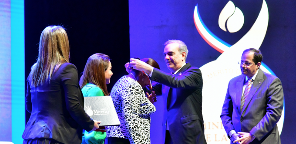 El presidente Luis Abinader coloca la medalla a una de las mujeres galardonadas.

Fotos Jorge Martínez.