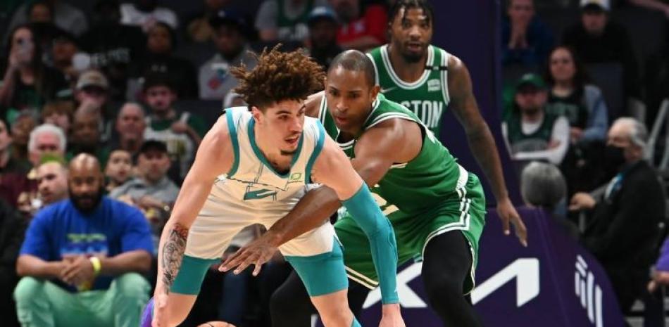 Al Horford, de los Celtics, trata de recuperar el balón de manos de LaMelo Ball, de los Hornets, en acción del partido del miércoles en el baloncesto de la NBA.