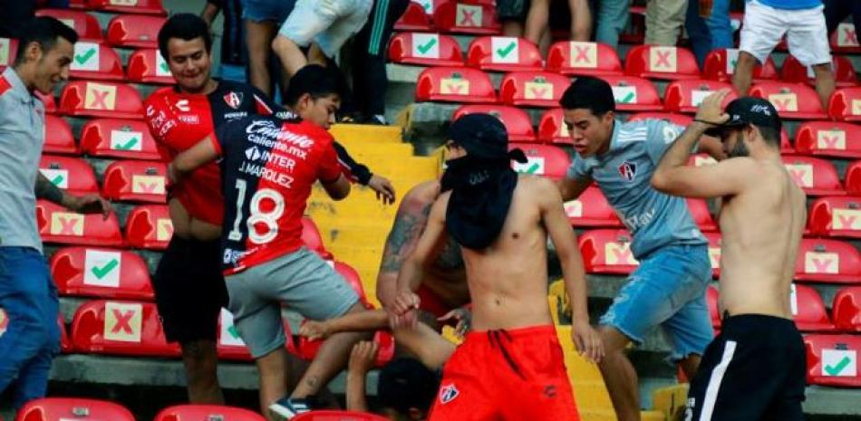 Fanáticos del Querétaro y del Atlas se enfrentan en las tribunas durante el partido del pasado sábado.