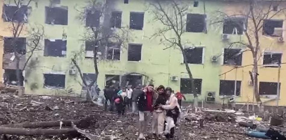 En esta captura de video de un material informativo tomado y publicado por la Policía Nacional de Ucrania el 9 de marzo de 2022, se ayuda a las personas a salir de un edificio dañado de un hospital infantil luego de un ataque aéreo ruso en la ciudad de Mariupol, en el sureste.
Folleto / Policía Nacional de Ucrania / AFP