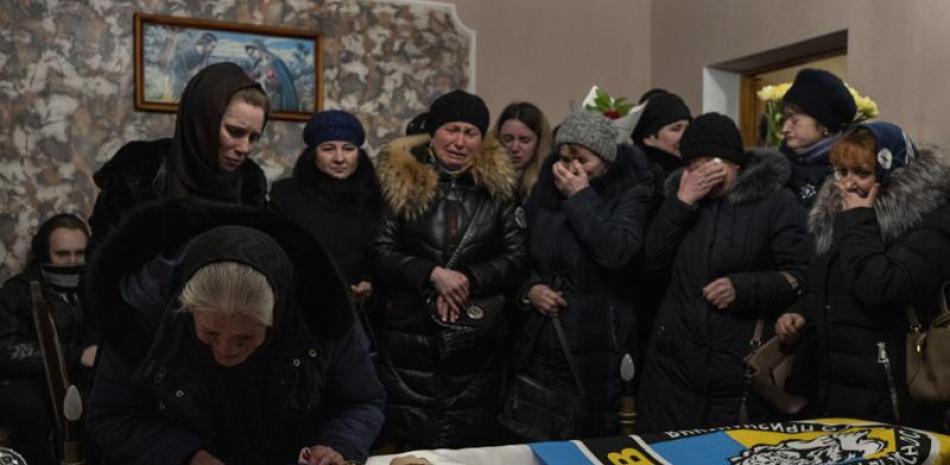 Familiares y amigos velan el cadáver del sargento de policía Roman Rushchyshyn, en la aldea de Soposhyn, a las afueras de Leópolis, Ucrania, el 10 de marzo de 2022. (AP Foto/Bernat Armangué)
