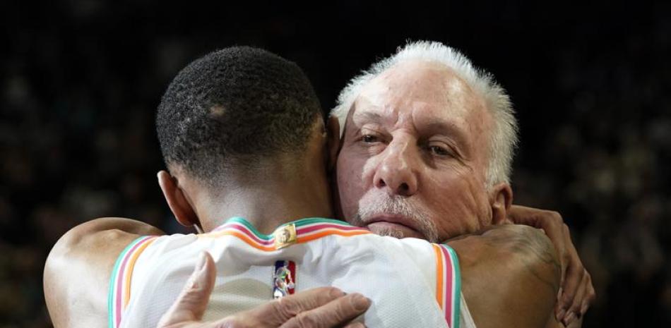 Greg Popovich recibe un abrazo del jugador Dejounte Murray luego del encuentro que los Spurs le ganaron a Utah.