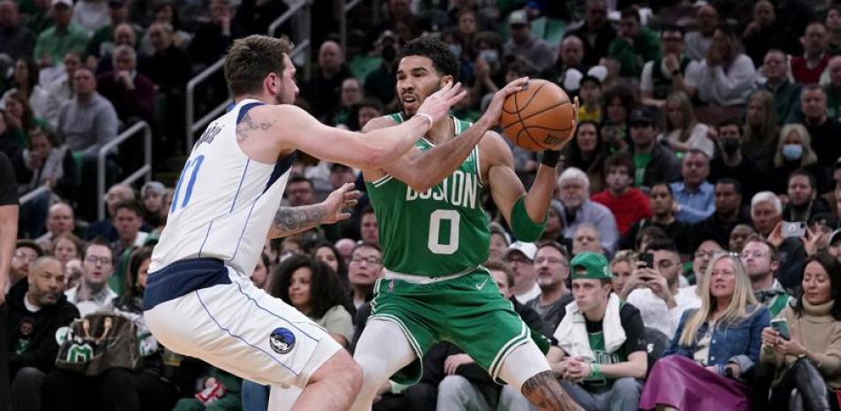 Jayson Tatum, de los Celtics, busca a quien pasar el balón ante la defensa de Luka Doncic.