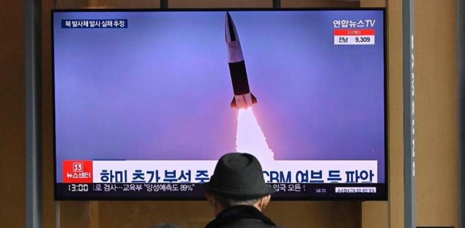 Varias personas observan una pantalla de televisión que muestra un telediario con imágenes de archivo de una prueba de misiles norcoreana, en una estación de ferrocarril de Seúl el 16 de marzo de 2022, después de que Corea del Norte disparara un "proyectil no identificado", pero que parece haber fracasado inmediatamente, según los militares del Sur. Foto: Jung Yeon-je/AFP.