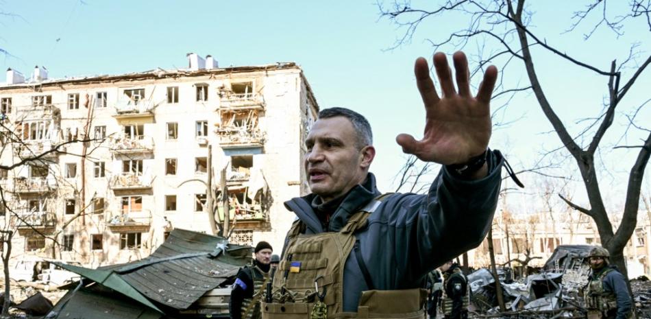 El alcalde de Kiev, Vitali Klitschko, aleja a la gente de un edificio residencial de cinco plantas que se derrumbó parcialmente tras un bombardeo en Kiev el 18 de marzo de 2022, mientras las tropas rusas intentan rodear la capital ucraniana como parte de su lenta ofensiva. Foto: Sergei Supinsky/AFP.