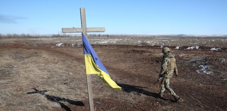 Un soldado ucraniano pasa por delante de un monumento hecho por él mismo en memoria de sus compañeros fallecidos a las afueras de Donetsk. Foto: Anatolii Stepanov/AFP.