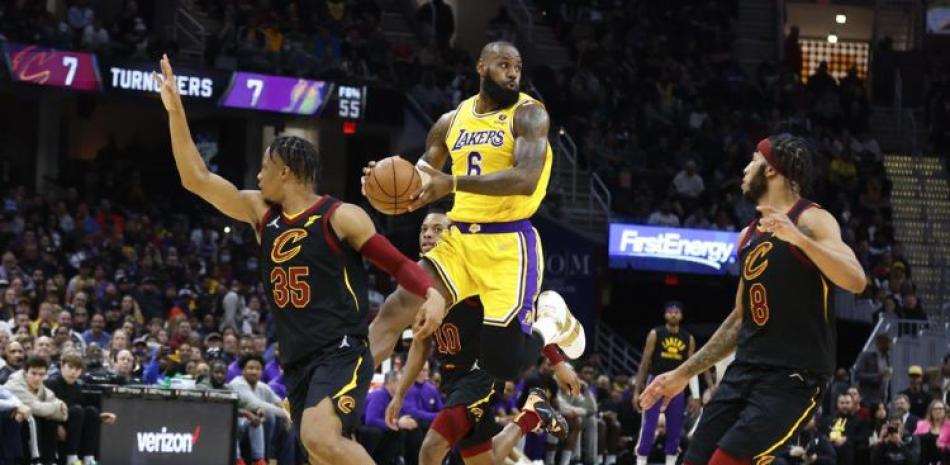 LeBron James, de los Lakers de Los Ángeles, pasa el balón a Isaac Okoro de los Cavaliers de Cleveland durante la segunda mitad del juego de la NBA.