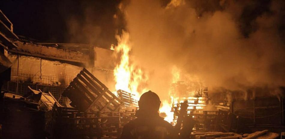 Esta foto de archivo, tomada y publicada por el Servicio de Prensa del Servicio Estatal de Emergencias de Ucrania el 21 de marzo de 2022, muestra a bomberos apagando un incendio a gran escala en un almacén de alimentos en Severodonetsk, región de Lugansk, destruido tras los bombardeos rusos.