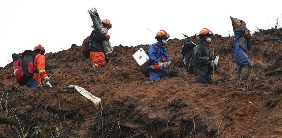 Trabajadores de rescate peinan el lugar donde se estrelló el vuelo MU5375 de China Eastern el 21 de marzo, cerca de Wuzhou, en la provincia suroccidental china de Guangxi, el 24 de marzo de 2022. Foto: Noel Celis/AFP.